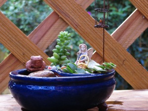 Side view of small blue bonsai with fairy, Timothy and hanging candle - with pond